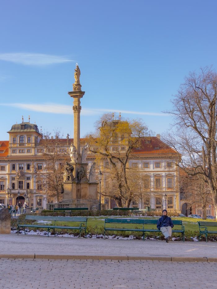 contact-img A peaceful winter scene showcasing a historic monument in a European square.
