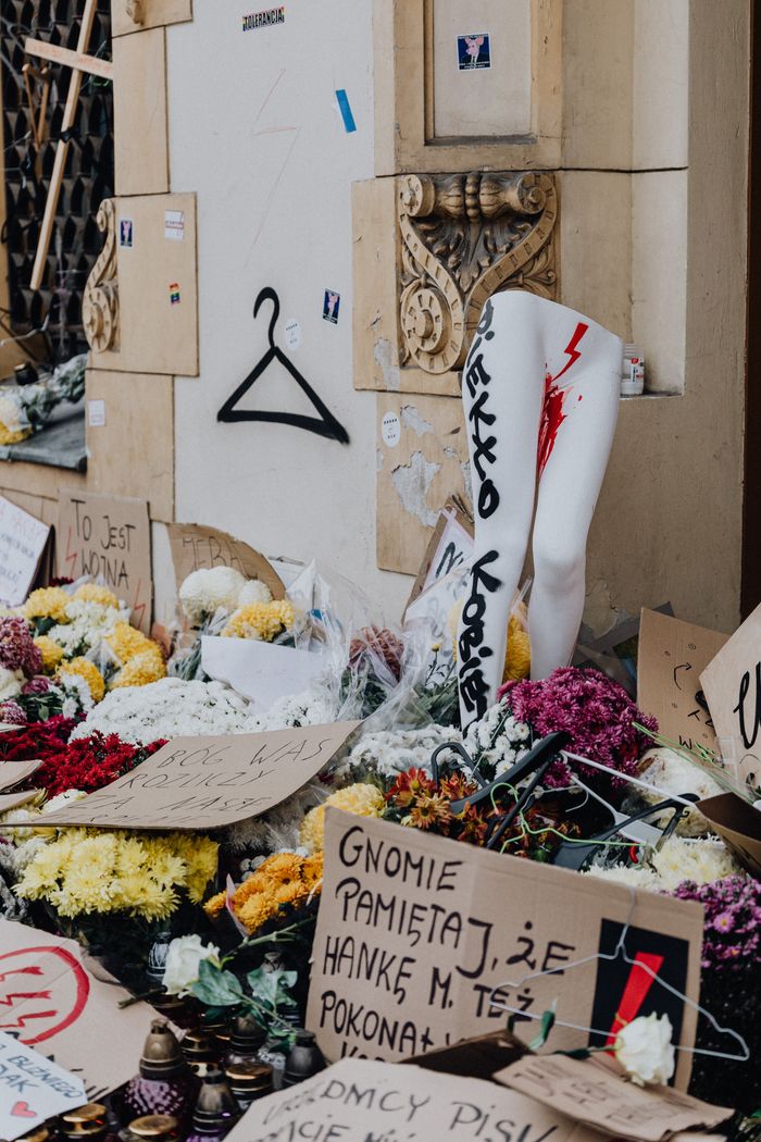 ours-journey Pro-choice protest scene in Poland with signs and flowers emphasizing women's rights and social justice.